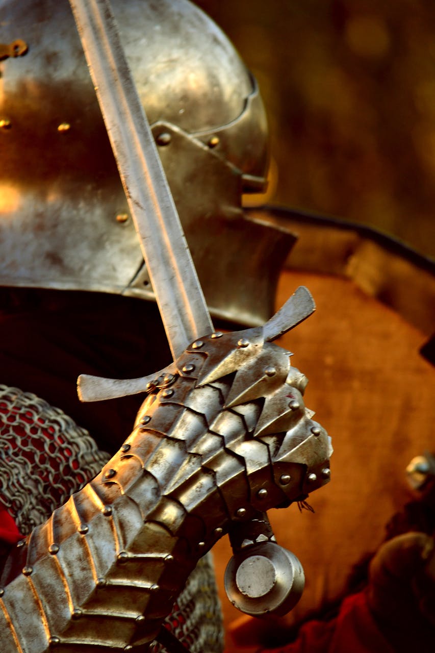 Profile of a knight in full armor; their helmet is turned away from the viewer and their hand in full scale is held up in front holding a sword at the ready