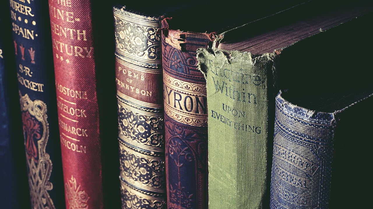 A photo of the top edges of six or seven older books on poetry. The spines show gilding and some wear where they've been well read.